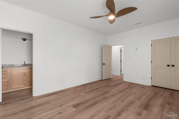 wooden floor in an empty room with a bathroom