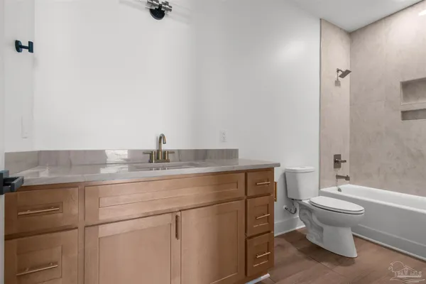 a bathroom with a granite countertop sink a toilet and shower