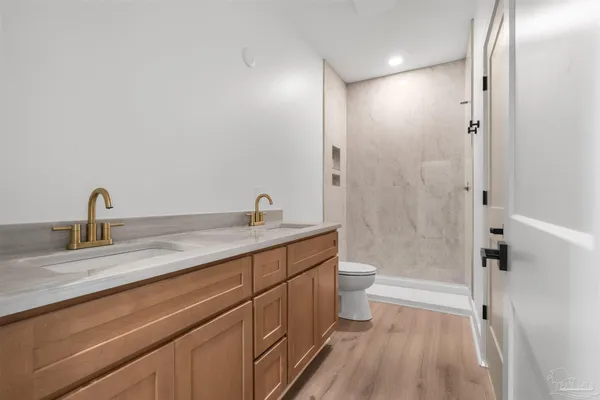 a bathroom with a double vanity sink toilet and shower