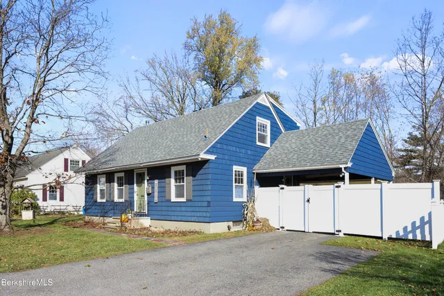 a front view of a house with a garden and trees