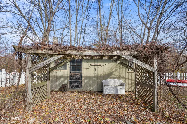a view of a patio with wooden fence and a bench
