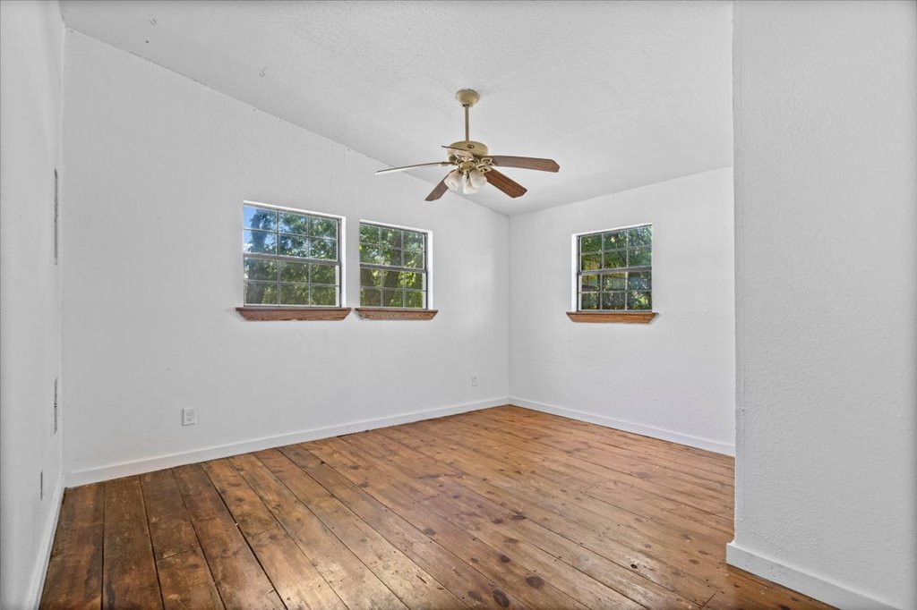 555 Harmon Hills Road, Unit A Dripping Springs, TX 78620 - Photo 21 of 29 Naturally illuminated room featuring durable hardwood flooring and a functional ceiling fan.