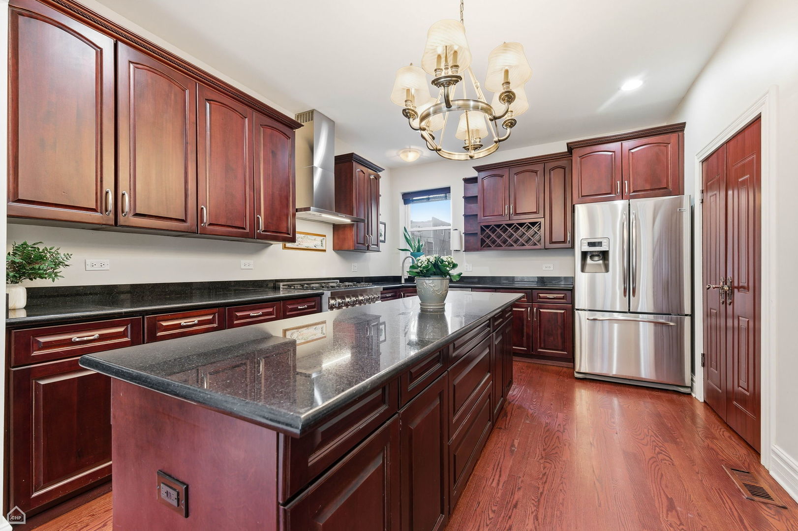 838 East 52nd Street, Unit 1W Chicago, IL 60615 - Photo 4 of 32 a kitchen with stainless steel appliances granite countertop a refrigerator a sink dishwasher a stove and a dining table with wooden floor