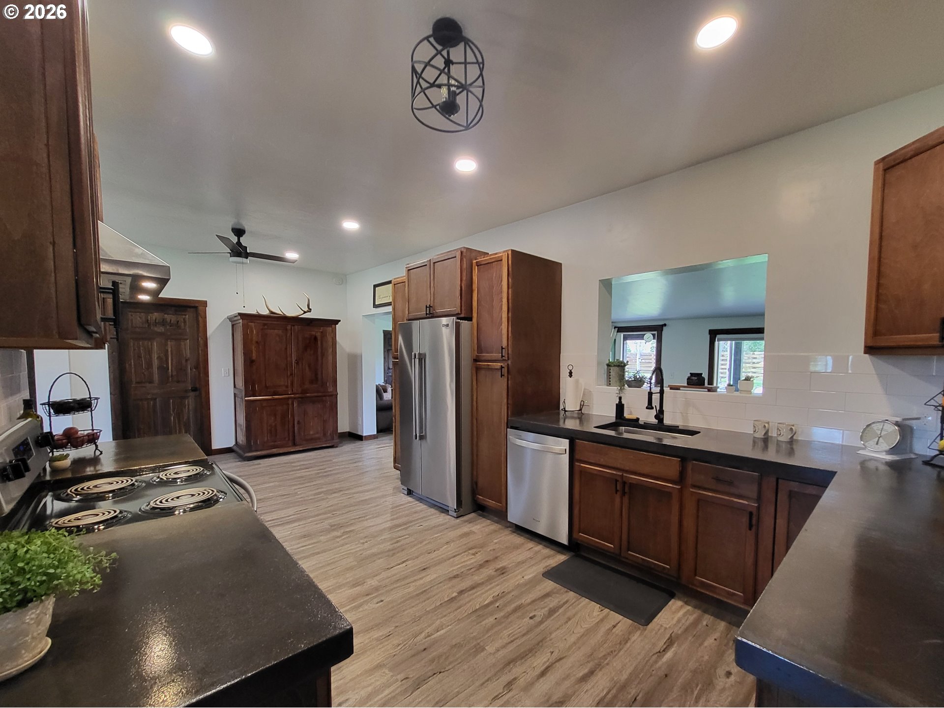 403 North Lake Street Joseph, OR 97846 - Photo 18 of 46 a kitchen with stainless steel appliances granite countertop a refrigerator a sink dishwasher a stove and a dining table with wooden floor