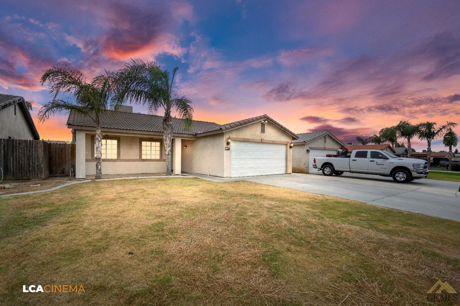 Undisclosed Address Bakersfield, CA 93308 - Photo 2 of 18 a front view of a house with a yard and garage