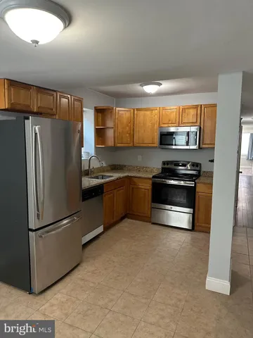 a kitchen with stainless steel appliances granite countertop a refrigerator and a stove
