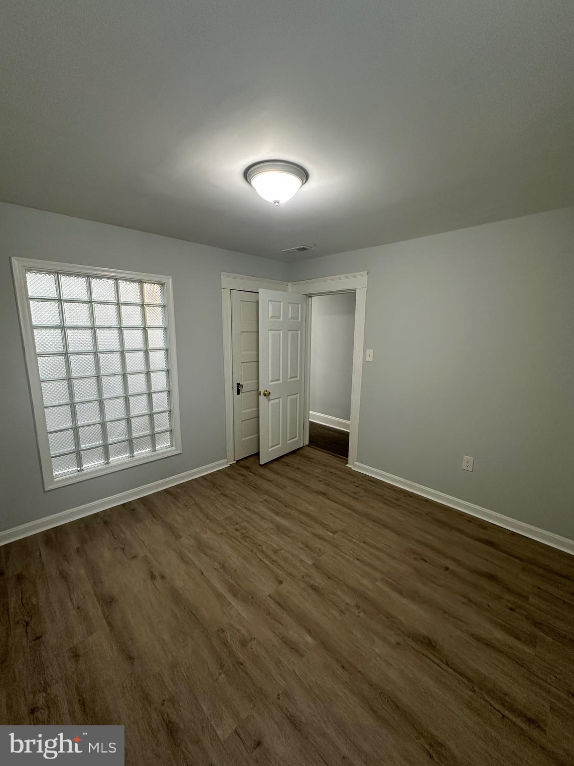 4331 Harford Road, Unit 2 Baltimore, MD 21214 - Photo 6 of 17 an empty room with wooden floor and windows