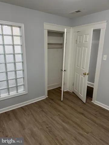 an empty room with wooden floor and window