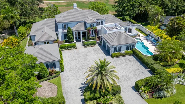 an aerial view of a house with swimming pool and garden