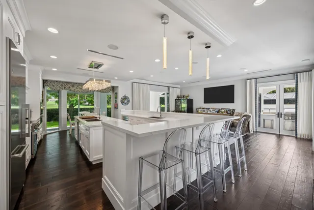 a kitchen with stainless steel appliances a dining table chairs stove and white cabinets