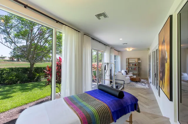 a bedroom with a bed and large windows
