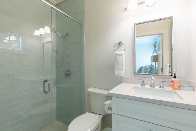 a bathroom with a sink a toilet and shower