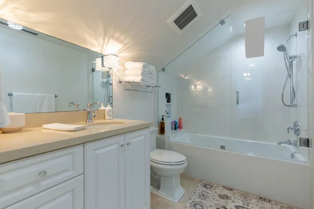 a bathroom with a granite countertop sink a toilet and bathtub