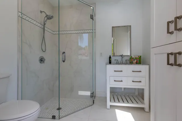 a bathroom with a shower sink vanity and toilet