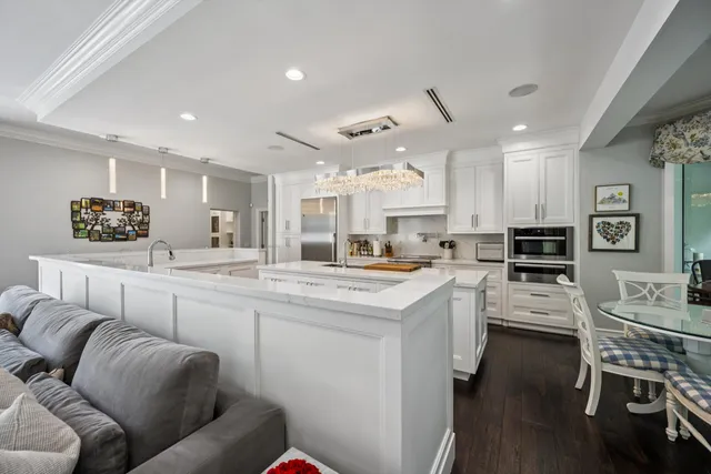 a kitchen with stainless steel appliances kitchen island granite countertop a stove and white cabinets