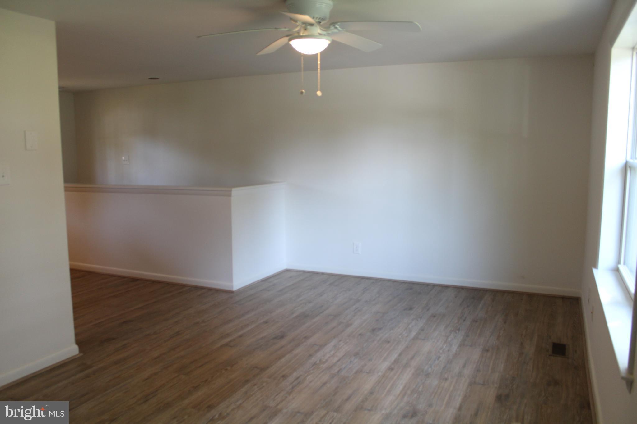 806 North Reymann Street Ranson, WV 25438 - Photo 4 of 25 an empty room with wooden floor fan and windows