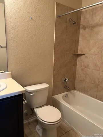 a white toilet sitting next to a bath tub
