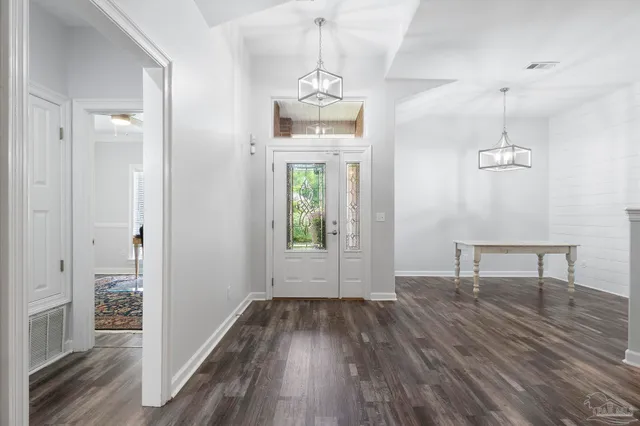 a view of a room with wooden floor a ceiling fan and windows