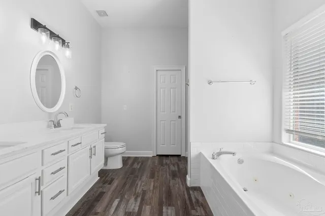 a spacious bathroom with a bathtub sink and mirror