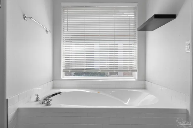 a bathroom with a bathtub and next to a window