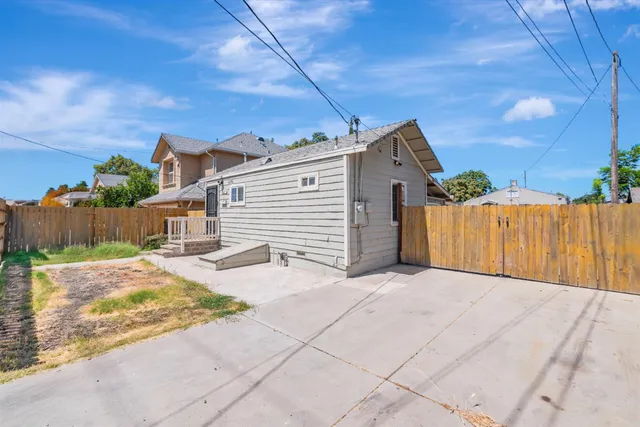 a view of a house with a small yard and wooden fence