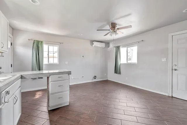 a view of an empty room with window and cabinet