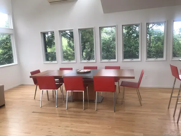 a dining room with furniture a rug and a floor to ceiling window