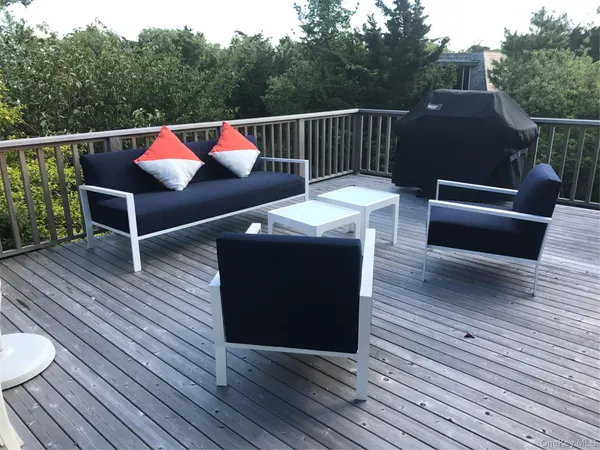 a balcony with wooden floor table and chairs