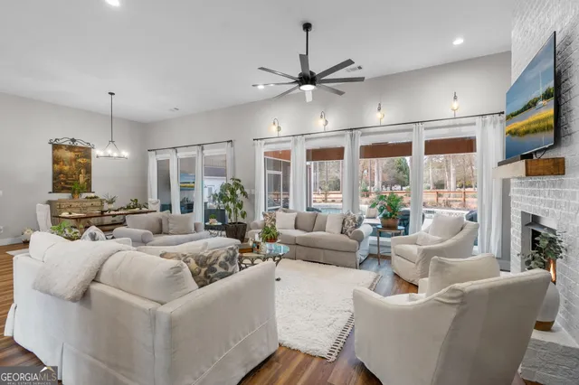 a living room with furniture a chandelier and a dining table