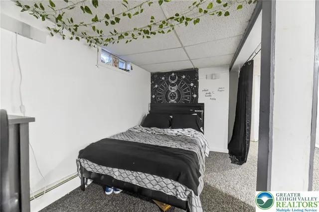 a bedroom with a bed and a flat tv screen on the dresser