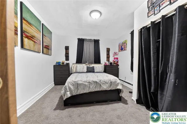 a bedroom with a bed closet and a flat tv screen