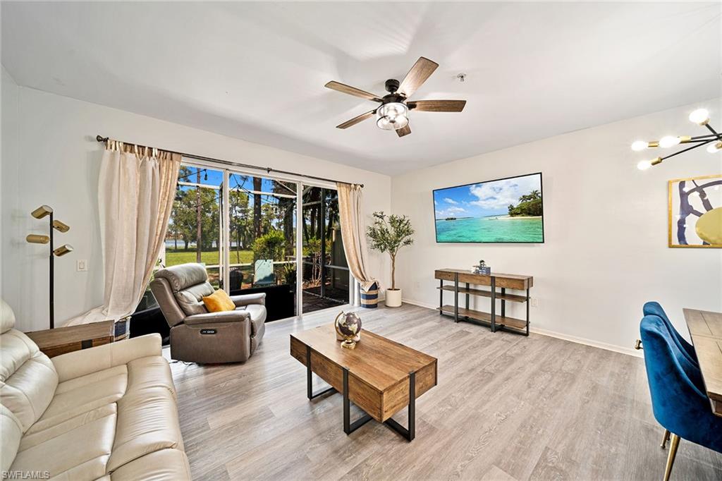 a living room with furniture a flat screen tv and a large window