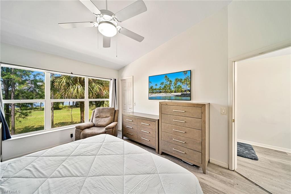 816 Hampton Circle Naples, FL 34105 - Photo 15 of 49 a bedroom with a bed and a large window with view of balcony
