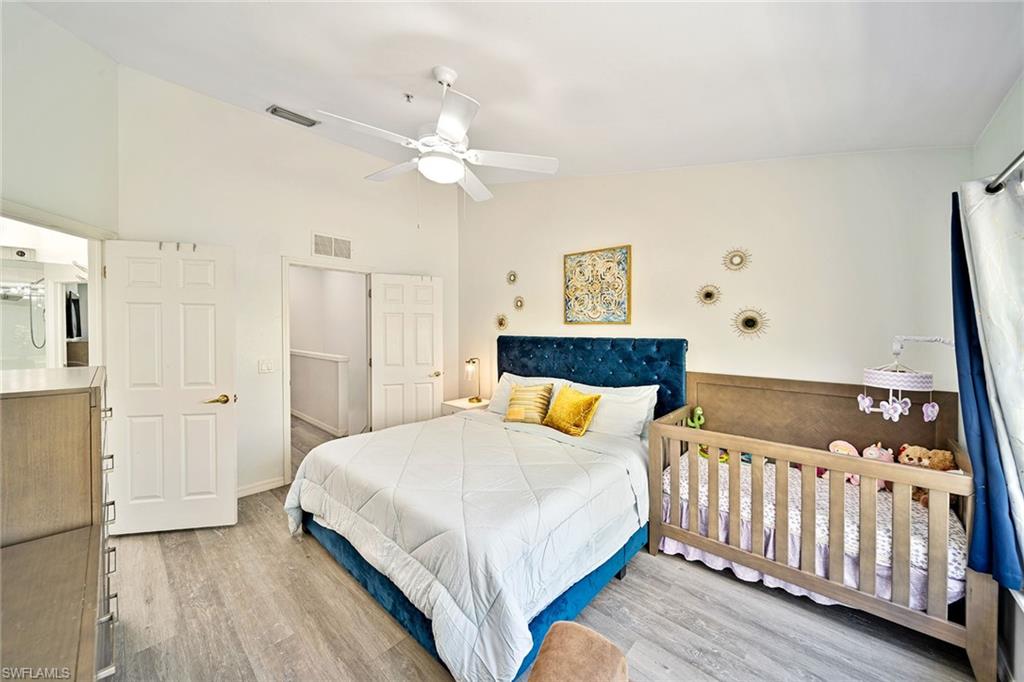 816 Hampton Circle Naples, FL 34105 - Photo 16 of 49 a bedroom with a bed and wooden floor