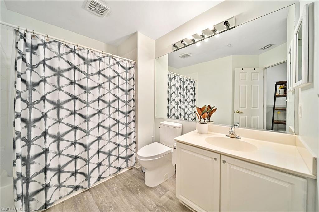 816 Hampton Circle Naples, FL 34105 - Photo 27 of 49 a bathroom with a sink a toilet and shower curtain