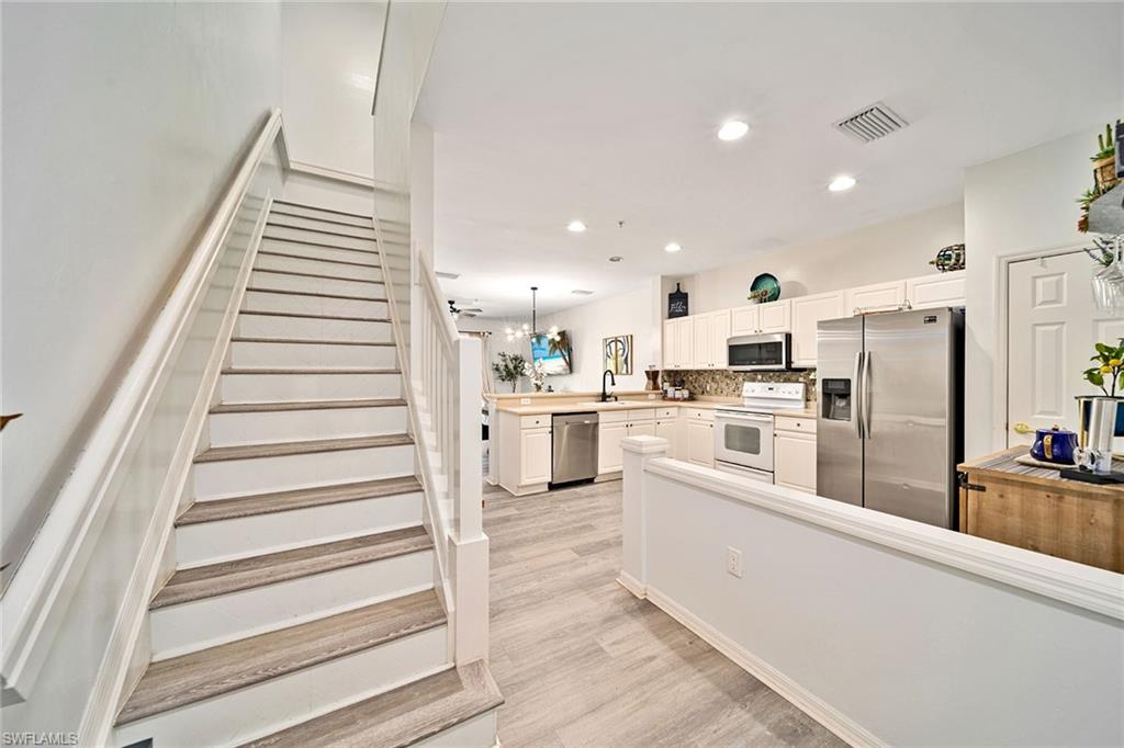 816 Hampton Circle Naples, FL 34105 - Photo 28 of 49 a kitchen with white cabinets and white appliances
