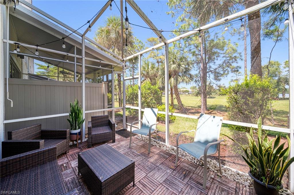816 Hampton Circle Naples, FL 34105 - Photo 31 of 49 a living room with large windows and wooden table