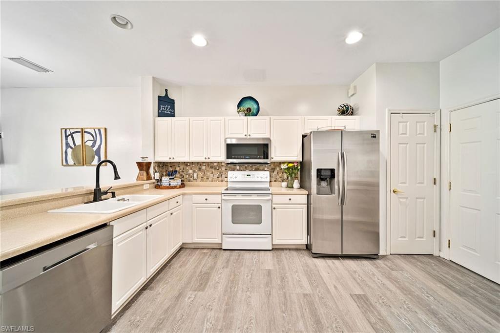 816 Hampton Circle Naples, FL 34105 - Photo 10 of 49 a kitchen with granite countertop a sink stainless steel appliances and cabinets