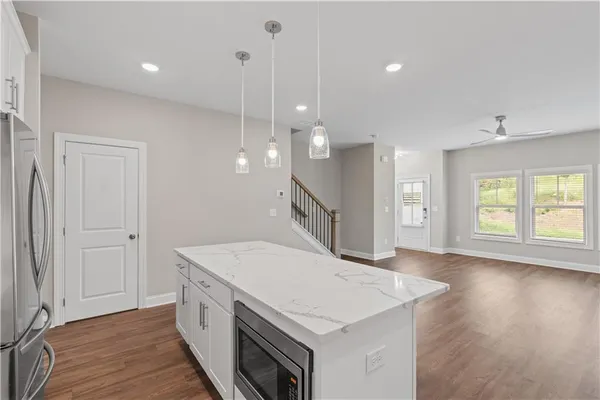 a open kitchen with a sink a window and wooden floor