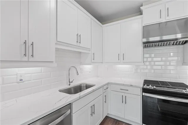a kitchen with white cabinets and appliances