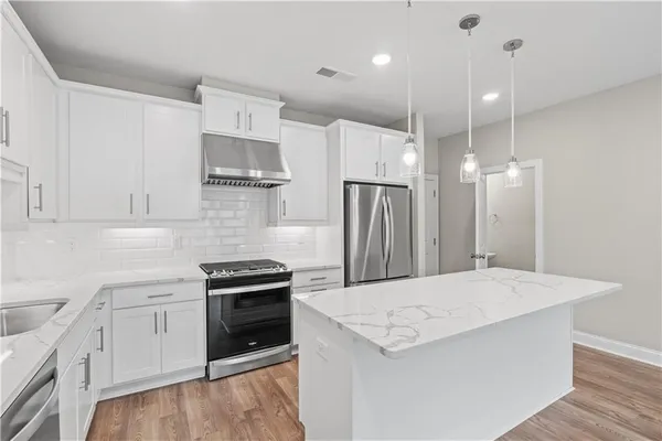 a kitchen with a stove a refrigerator and a sink