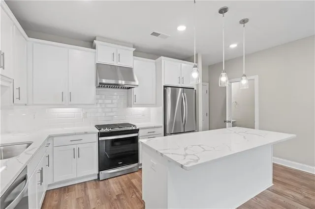 a kitchen with a stove a refrigerator and a sink