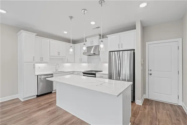 a kitchen with a stove a sink and a refrigerator