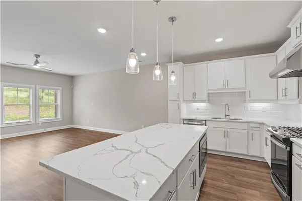 a kitchen with kitchen island a sink stainless steel appliances and cabinets