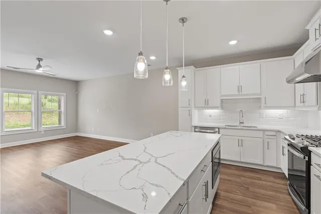 a kitchen with kitchen island a sink stainless steel appliances and cabinets