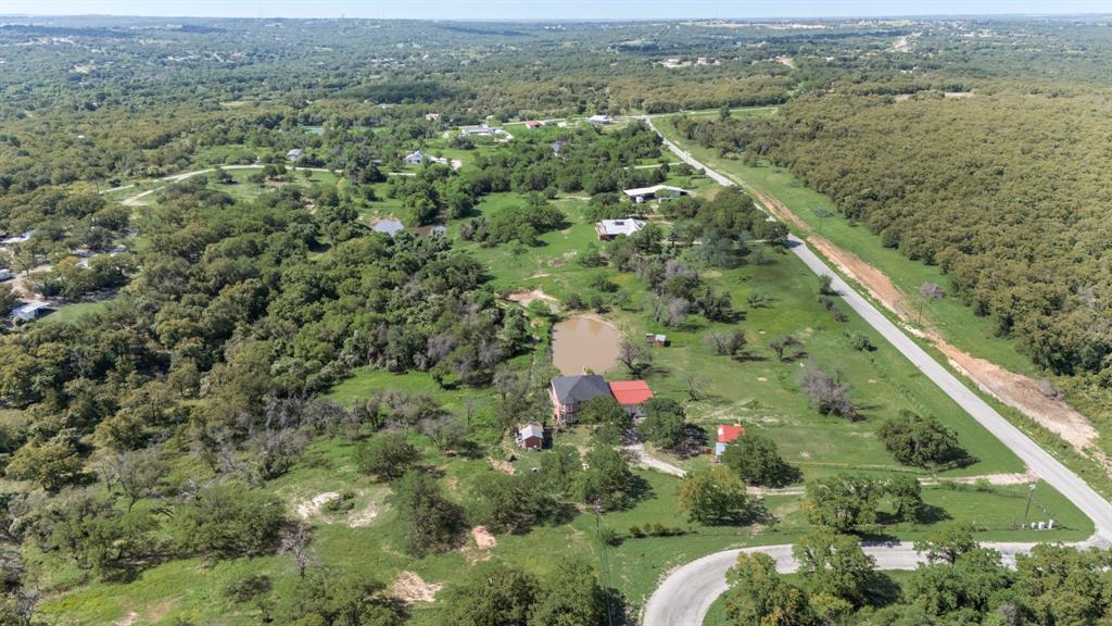 an aerial view of residential houses with outdoor space and trees