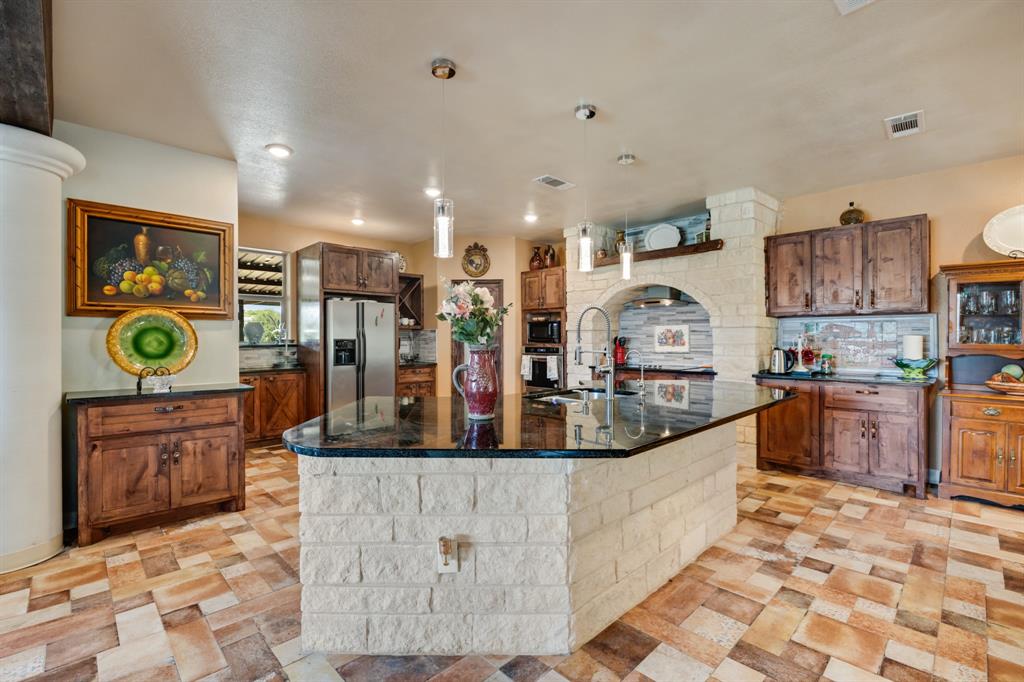 2277 County Road 3657 Springtown, TX 76082 - Photo 24 of 40 a large kitchen with stainless steel appliances granite countertop a stove and a sink
