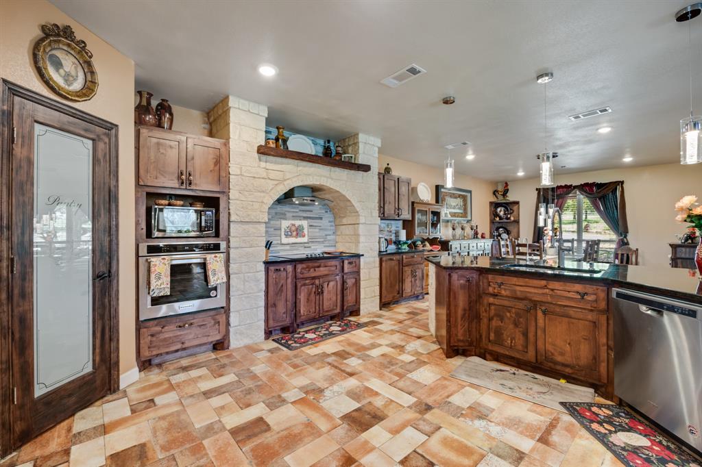 2277 County Road 3657 Springtown, TX 76082 - Photo 25 of 40 a kitchen with stainless steel appliances granite countertop a refrigerator and a stove top oven