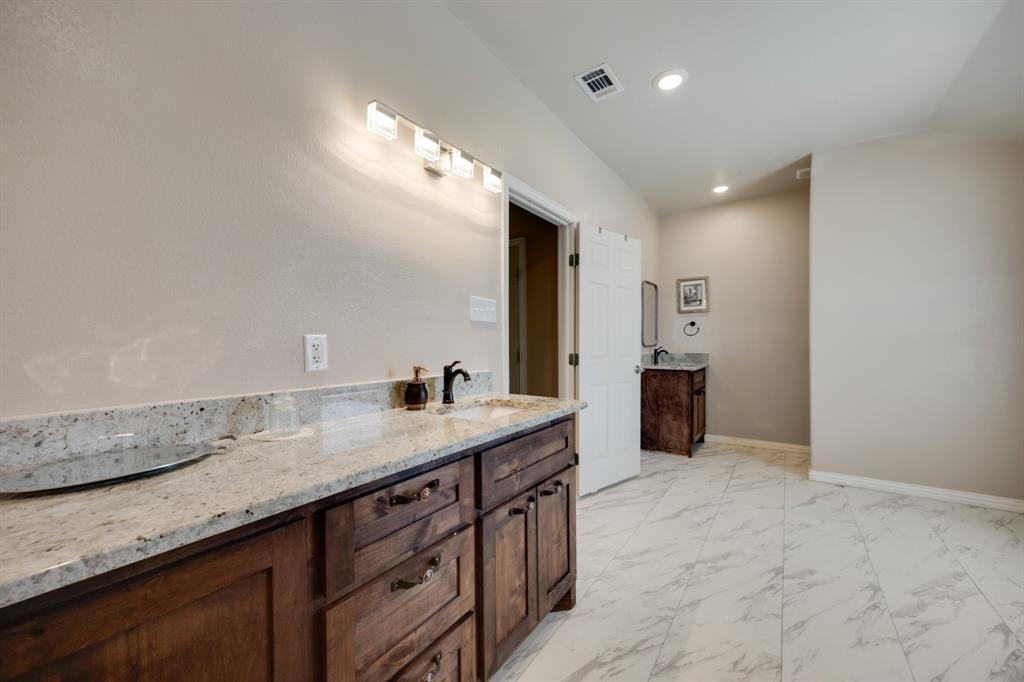 2277 County Road 3657 Springtown, TX 76082 - Photo 37 of 40 a bathroom with a granite countertop sink and a mirror