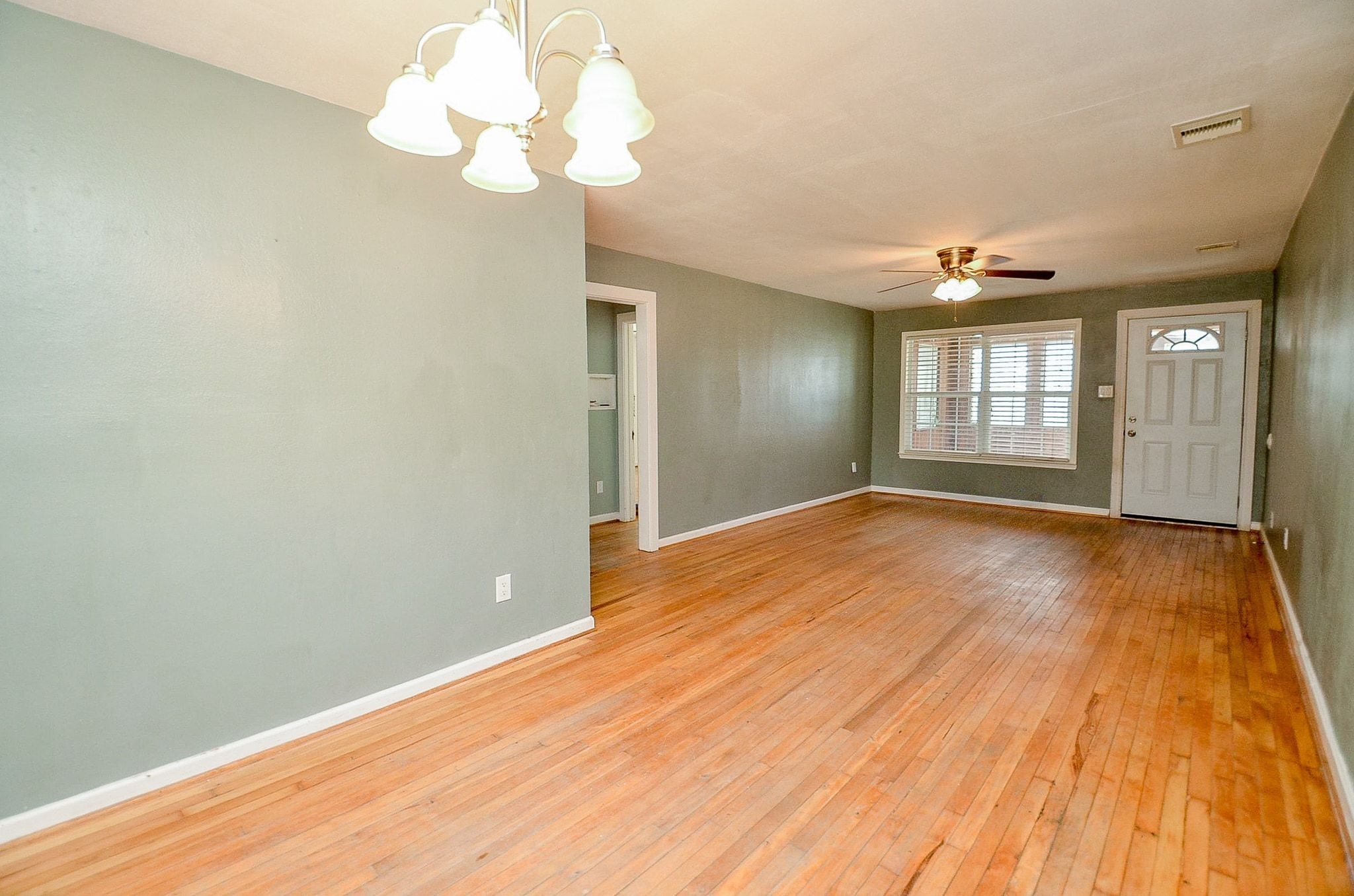7707 Scanlock Street Houston, TX 77012 - Photo 11 of 19 a view of an empty room with wooden floor and a window